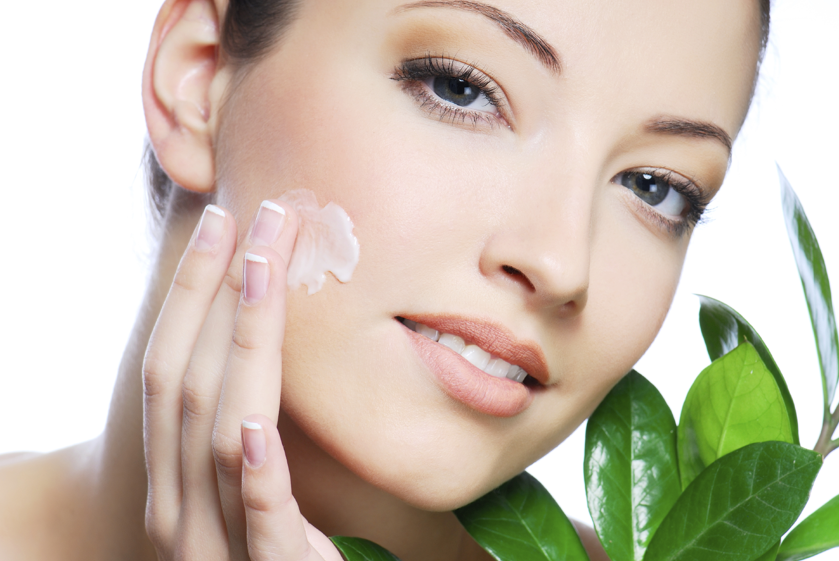 Woman applying anti aging cream on face.